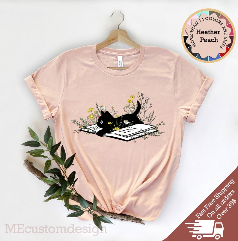 May include: A black cat reading a book surrounded by flowers. The cat is lying on the book with its head resting on the page. The flowers are in shades of yellow and white.