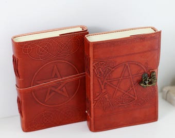 May include: Two brown leather journals with pentacle designs and a lock on one. The journals have a distressed look and are closed.