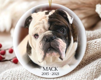 Könnte beinhalten: Runder, weißer Keramikschmuck mit einem Foto eines Bulldoggen-Gesichts. Der Hund hat ein schwarz-weißes Fell. Der Name "MACK" und die Jahre "2015-2021" sind auf dem Ornament aufgedruckt. Ein goldener Faden ist befestigt.