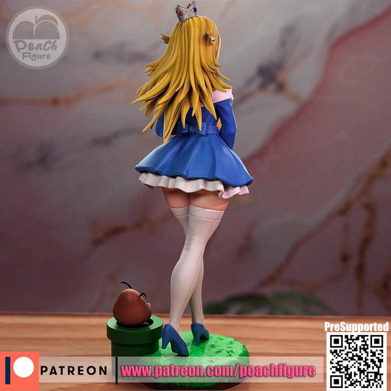 K&ouml;nnte beinhalten: Figur einer Figur mit langen blonden Haaren, die ein blaues Kleid mit wei&szlig;em Besatz und blaue Abs&auml;tze tr&auml;gt. Die Figur steht auf einer gr&uuml;nen Basis mit einem braunen Pilz und einem gr&uuml;nen Rohr. Die Figur hat eine Krone auf dem Kopf. Der Text "Peach Figure" ist sichtbar.
