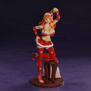 May include: A figurine of a female character with long orange hair wearing a red and white Santa-themed outfit with snowflake patterns. The character holds a small gold bell above her head and is posed standing next to a dark brown wooden stool.