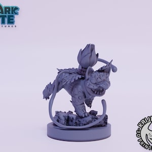 May include: A gray, 3D printed miniature of a mythical creature with a flower on its head. The creature has a cat-like body with wings and a long tail. The miniature is standing on a round base.