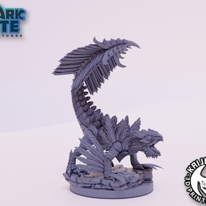 Puede incluir: Una miniatura gris de una criatura estilizada con un cuerpo largo y segmentado y una gran cresta emplumada. La criatura tiene una superficie texturizada y detallada y está posada sobre una base rocosa. Los logotipos de Shark Bite Miniatures y Kaijumon 3D Printing son visibles.