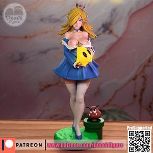 K&ouml;nnte beinhalten: Figur einer weiblichen Figur mit blonden Haaren, die ein blaues Kleid tr&auml;gt und einen gelben sternf&ouml;rmigen Gegenstand h&auml;lt. Die Figur steht auf einer gr&uuml;nen Basis mit einem gr&uuml;nen Rohr und einer braunen Kreatur. Die Figur hat eine Krone und tr&auml;gt wei&szlig;e Str&uuml;mpfe.