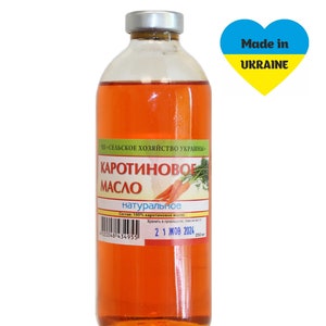 Puede incluir: Una botella de vidrio de aceite de zanahoria de color naranja con una etiqueta blanca que dice "Каротиновое Масло натуральное" (Aceite de zanahoria natural) y una fecha de caducidad de "21 ЖОВ 2024". La botella est&aacute; etiquetada con "Made in UKRAINE" con un coraz&oacute;n amarillo y azul.