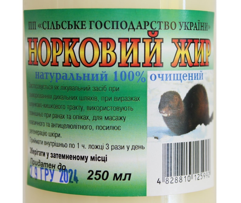 May include: A white bottle with a green label that reads "Норковий жир натуральний 100% очищений". The label also includes a picture of a mink and a barcode. The bottle contains 250 ml of mink oil.