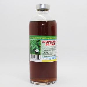 Puede incluir: Una botella de vidrio marr&oacute;n con una tapa plateada, etiquetada "Лапчатка Белая" (Potentilla alba) con un c&oacute;digo de barras y una fecha de caducidad del 15 Дек 2022. La botella contiene un l&iacute;quido oscuro y probablemente sea un remedio herbal.