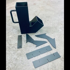 May include: A black metal wood burning stove insert with a chimney extension and a set of metal plates for installation.
