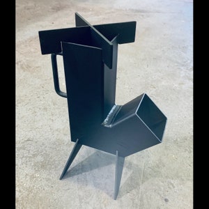 May include: A black metal wood-burning stove with a side-mounted exhaust pipe and a handle. The stove has four legs and a cross-shaped top.