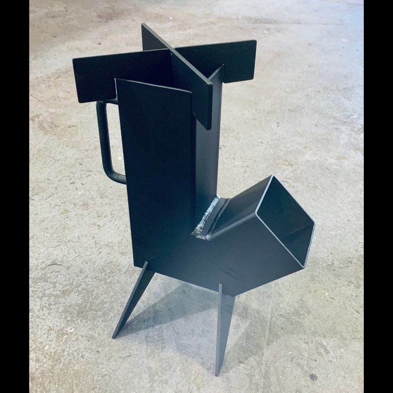 May include: A black metal wood-burning stove with a side-mounted exhaust pipe and a handle. The stove has four legs and a cross-shaped top.