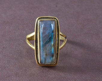 May include: A gold ring with a rectangular blue and gray gemstone.