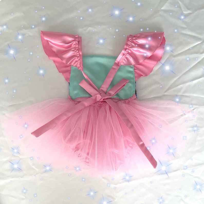 May include: A pink tulle tutu with a light blue bodice and pink satin straps. The bodice has a bow in the back.