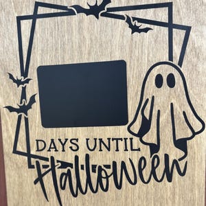 May include: Wooden Halloween countdown sign with a black frame, bats, and a ghost. The sign reads "DAYS UNTIL Halloween" with a blank chalkboard area for daily updates. A festive decoration.