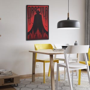 May include: A framed poster with a red background and a black silhouette of Dracula standing in front of a castle. The poster has the word "Dracula" in white letters at the top.