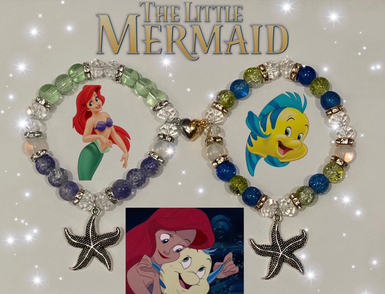 May include: Two beaded bracelets with charms. One bracelet has blue, green, and clear beads with a gold charm and a silver starfish charm. The other bracelet has purple, blue, green, and clear beads with a silver starfish charm. The bracelets feature images of Ariel and Flounder from The Little Mermaid.