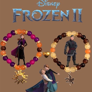 May include: Two beaded bracelets with charms, one with a sun and the other with a maple leaf. The bracelets feature images of characters from the Disney movie Frozen II, including Elsa, Anna, and Kristoff.