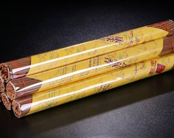 Op de afbeelding: Vijf bundels bruine wierookstokjes verpakt in geel papier met Chinese karakters gedrukt op de verpakking. De verpakking is van doorzichtig plastic.