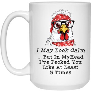 May include: White ceramic mug featuring a cartoon chicken wearing glasses and a red bandana. The text on the mug reads "I May Look Calm... But In MyHead I've Pecked You Like At Least 3 Times."