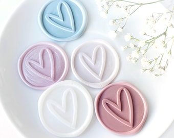 Op de afbeelding: Vijf waszegels met een hartvormig ontwerp. De zegels zijn in tinten blauw, roze en wit.