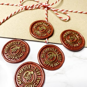 May include: Four red wax seals with gold lettering and a Santa Claus image. The seals read "North Pole Official Seal".