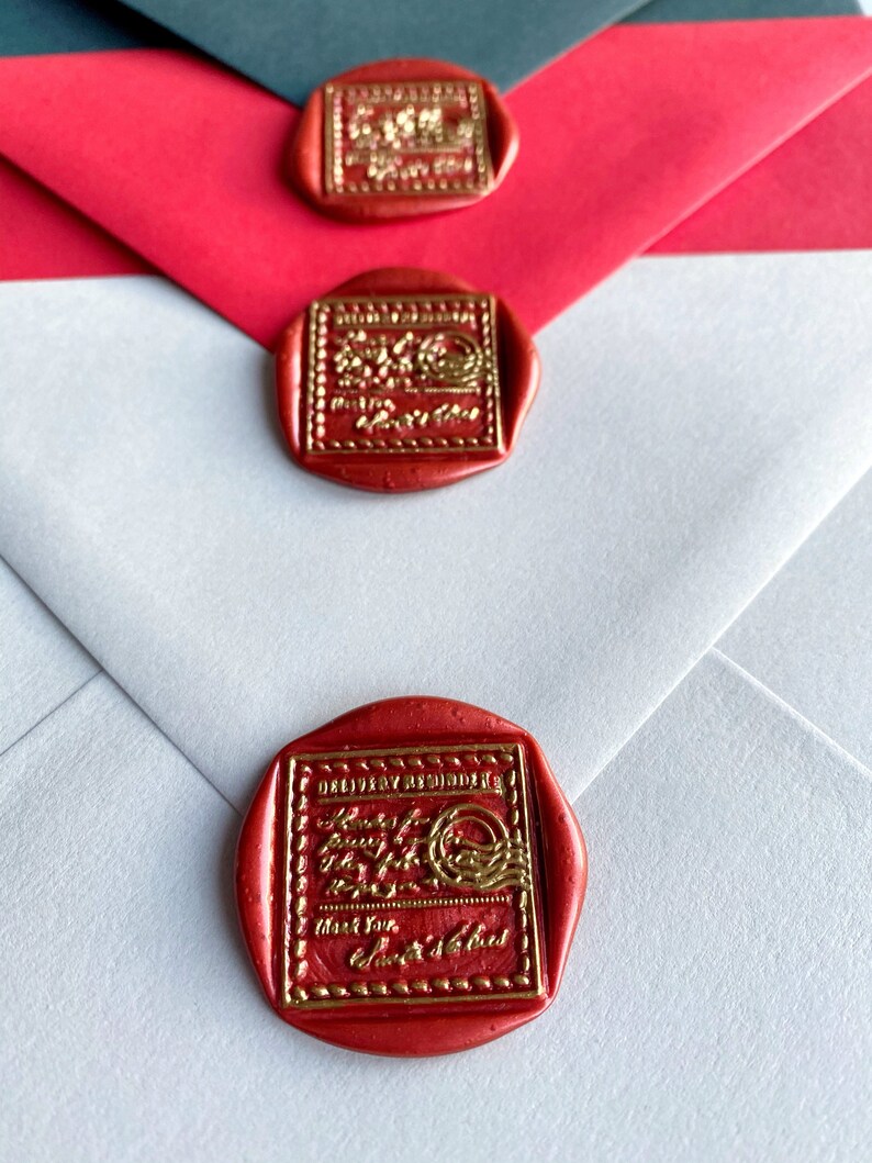 Puede incluir: Primer plano de tres sobres con sellos de cera rojos. Los sellos tienen letras doradas y un borde decorativo. Los sobres son blancos, rojos y gris oscuro. El texto del sello dice "Delivery Reminder" y "Thank You".