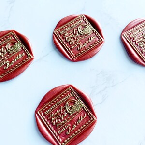 Puede incluir: Sellos de cera rojos con texto dorado en relieve y bordes decorativos esparcidos sobre una superficie de m&aacute;rmol blanco. Los sellos tienen un centro cuadrado con esquinas redondeadas y un borde exterior circular. El texto dice "Hours of Joy, Thank You, Sweetest of Dad."