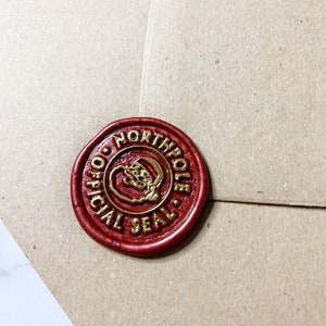 May include: A red wax seal with a gold inscription that reads "Official North Pole Seal".