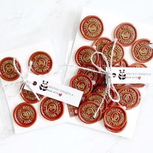 May include: A set of 20 red wax seals with gold lettering. The seals say "North Pole Official Seal". The seals are packaged in two clear plastic bags with white labels that say "Mitchkin Designs made with ❤️".