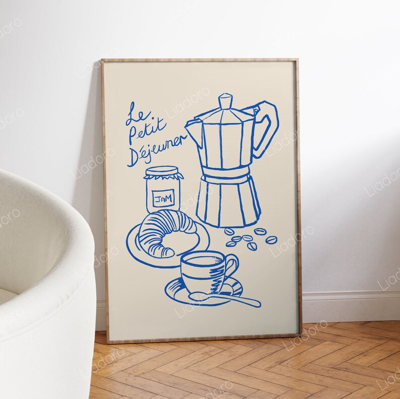 May include: A framed illustration of a French breakfast scene with blue line drawings of a coffee pot, a croissant, a jar of jam, a cup of coffee, and coffee beans. The text "Le Petit D&eacute;jeuner" is written in blue cursive.