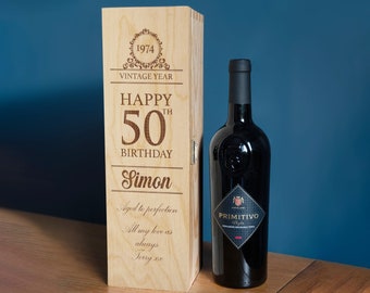 May include: A wooden wine box with a personalized message for a 50th birthday. The box is engraved with the text "Happy 50th Birthday Simon" and "Aged to perfection". The box is closed and a bottle of wine is visible in the background.
