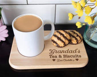 May include: A wooden tray with a white mug, two chocolate-covered coconut biscuits, and the text "Grandad's Tea & Biscuits Love Charlotte x".
