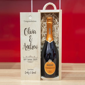 Puede incluir: Una caja de regalo de madera con una botella de Maschio Prosecco en su interior. La caja está grabada con el texto "Felicidades Olivia & Andrew 18 de abril de 2019 Con cariño de Emily & David".