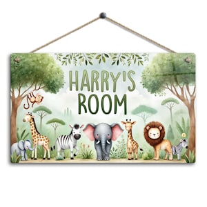 May include: A rectangular sign with the text "HARRY'S ROOM" in green letters, featuring a jungle scene with cartoon animals. The animals include a giraffe, zebra, elephant, lion, and monkey. The sign is suspended by a natural fibre rope.