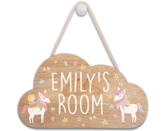 May include: A wooden cloud-shaped door sign with the text "Emily's Room" in white lettering. The sign features two unicorns with rainbow manes and a girl riding one of the unicorns. The sign is decorated with small stars and flowers.