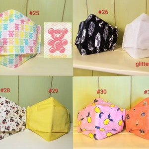 K&ouml;nnte beinhalten: Zehn verschiedene Stoffmasken mit verschiedenen Mustern, darunter Teddyb&auml;ren, Federn, Zitronen und Blumen. Die Masken sind von 25 bis 31 nummeriert.