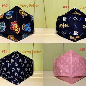 K&ouml;nnte beinhalten: Vier verschiedene Gesichtsmasken. Die ersten beiden sind schwarz mit Harry-Potter-Motiven. Die dritte ist schwarz mit einem wei&szlig;en Dreiecksmuster. Die vierte ist rosa mit einem wei&szlig;en Kreuzmuster.