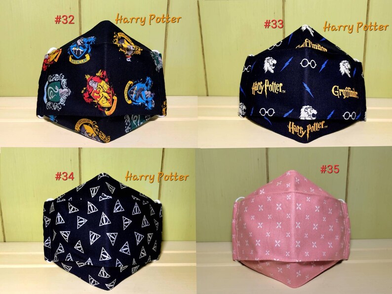 K&ouml;nnte beinhalten: Vier verschiedene Gesichtsmasken. Die ersten beiden sind schwarz mit Harry-Potter-Motiven. Die dritte ist schwarz mit einem wei&szlig;en Dreiecksmuster. Die vierte ist rosa mit einem wei&szlig;en Kreuzmuster.