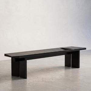 以下が含まれることがあります： ミニマルなデザインのモダンな黒い木製ベンチ。 長い長方形の座面は、頑丈な長方形の脚の2つのセットによって支えられています。 ベンチの長さは約183cm、幅41cm、高さ46cmです。