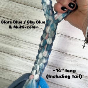 May include: A medium-sized dog toy with a handle, featuring a braided design in slate blue, sky blue, and multi-color. The toy has a stripe pattern and is approximately 14 inches long, including the tail.