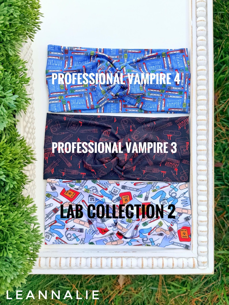 Op de afbeelding: Drie stoffen haarbanden met een gedraaid knoopontwerp. De bovenste haarband is blauw met medische thema-afbeeldingen en de tekst "PROFESSIONAL VAMPIRE 4". De middelste haarband is zwart met rode medische afbeeldingen en de tekst "PROFESSIONAL VAMPIRE 3". De onderste haarband is lichtblauw met medische afbeeldingen en de tekst "LAB COLLECTION 2".