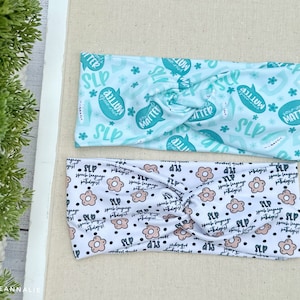 May include: Two headbands with different patterns. The first headband is light blue with white flowers and the text "Your Words Matter" and "SLP". The second headband is white with black dots and pink flowers and the text "Speech Language Pathologist" and "SLP".