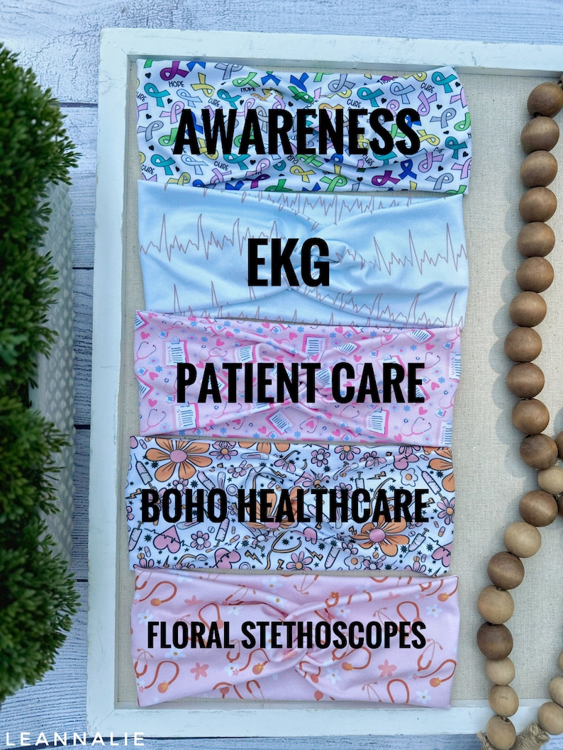 K&ouml;nnte beinhalten: F&uuml;nf bunte Stirnb&auml;nder mit verschiedenen Designs. Das obere Stirnband hat einen wei&szlig;en Hintergrund mit rosa, blauen und gr&uuml;nen Schleifendesigns und die Worte "AWARENESS" in Schwarz. Das zweite Stirnband hat einen wei&szlig;en Hintergrund mit einem hellblauen EKG-Muster. Das dritte Stirnband hat einen rosa Hintergrund mit einem wei&szlig;en Patientenpflege-Design. Das vierte Stirnband hat einen wei&szlig;en Hintergrund mit einem rosa und gelben Blumendesign und die Worte "BOHO HEALTHCARE" in Schwarz. Das f&uuml;nfte Stirnband hat einen rosa Hintergrund mit einem wei&szlig;en Blumendesign und die Worte "FLORAL STETHOSCOPES" in Schwarz.