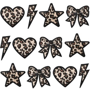 Pode incluir: Uma coleção de patches de estampa de leopardo em várias formas, incluindo corações, estrelas, raios e laços. Cada patch apresenta um padrão de leopardo bege e marrom com uma borda preta. Ideais para personalizar roupas ou acessórios.