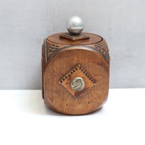 May include: A wooden box with a silver knob on the lid. The box has a carved design and a metal plaque with a horse on it.