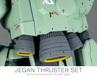 May include: Close-up of a light green model kit with gray thrusters and yellow accents. The text "JEGAN THRUSTER SET" is displayed at the bottom, along with "-3D Printed Conversion For MG Jegan-".