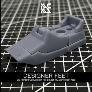 May include: Gray 3D printed plastic feet for model kits. The feet have a detailed design with multiple sections and a textured surface. "DESIGNER FEET - 3D Printed Conversion For Select MG 2.0 Model Kits -" is printed on the bottom of the image.