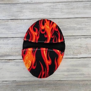 May include: A black fabric pot holder with a red and orange flame pattern.