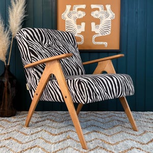 Sillón artesanal de mediados de siglo con estampado de cebra y estructura de madera de haya.