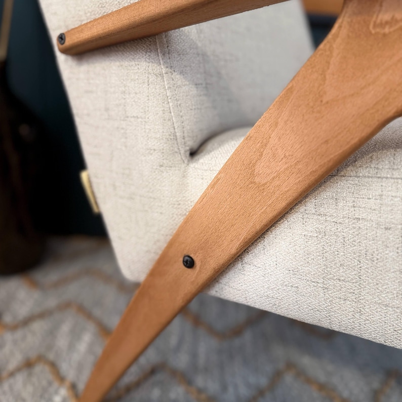 V-shaped beech leg fastened with black screw to cushioned seat, highlighting sturdy construction