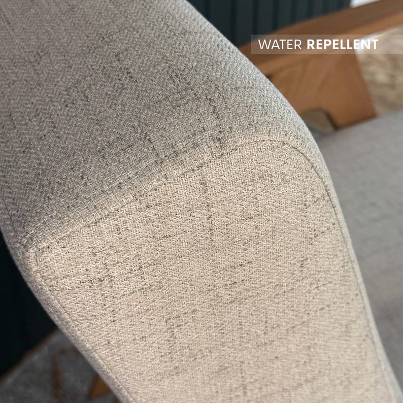 Beige textured fabric armrest labelled “water repellent” showing stain-resistant upholstery